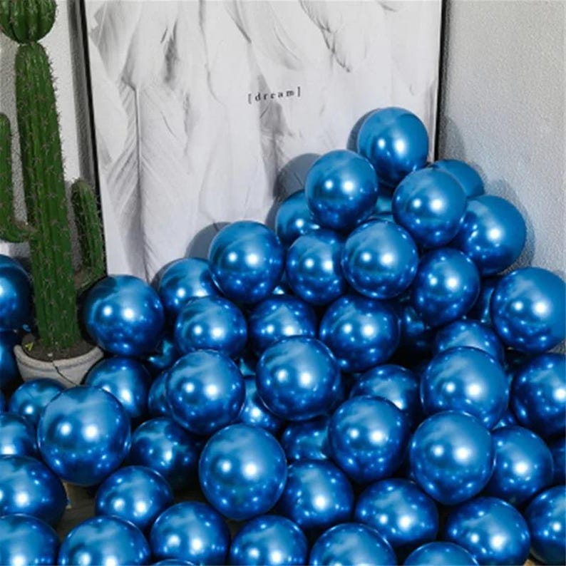 May include: A large pile of shiny blue balloons. The balloons are arranged in a random pattern and are all the same size.