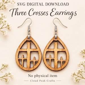 May include: A pair of teardrop-shaped wooden earrings featuring a cutout design of three crosses. The earrings hang from silver-toned metal hooks. The text SVG DIGITAL DOWNLOAD Three Crosses Earrings No physical item Cloud Peak Crafts is visible.