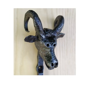 Forged head of a ram, forged hanger in a hunting lodge, artistic forged sculpture , forged hook