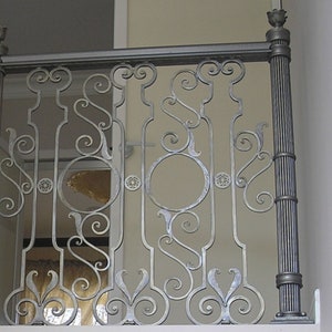 May include: Silver wrought iron balustrade with decorative scrollwork, circular and floral details. The design includes vertical posts with fluted detailing and finials, creating an elegant architectural feature.