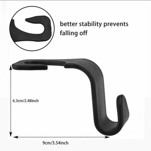 May include: Black plastic car seat hook with a 6.3 cm / 2.48 inch height and 9 cm / 3.54 inch width. The hook has a curved design to prevent items from falling off.