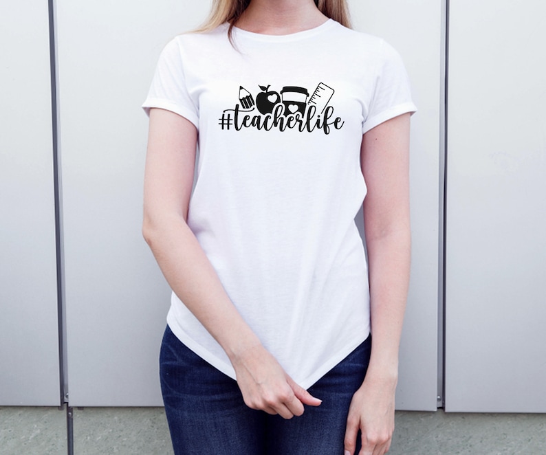May include: White t-shirt with a black graphic of school supplies and the text "#teacherlife"