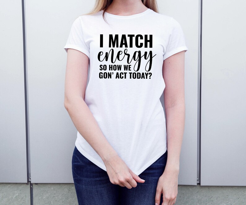 May include: White t-shirt with black text that reads "I match energy so how we gon' act today?"