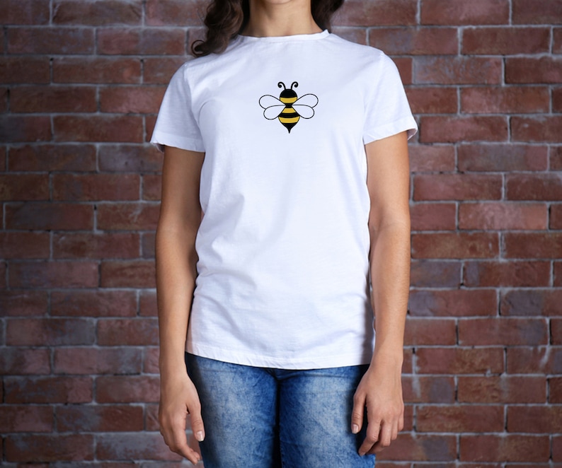 May include: White t-shirt with a black and yellow bee graphic on the front.