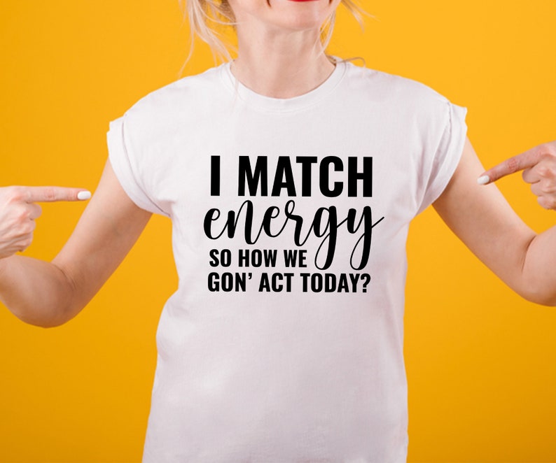 May include: White t-shirt with black text that reads "I match energy so how we gon' act today?"