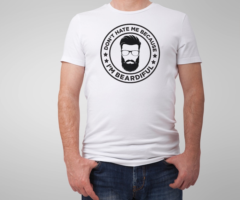 May include: White t-shirt with a black and white graphic of a man with a beard and glasses. The graphic is inside a circle with the text "Don't hate me because I'm beardful".