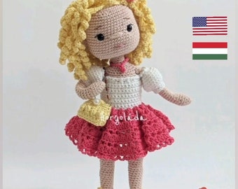 Könnte beinhalten: Eine gehäkelte Puppe mit blonden Locken, die ein weißes Oberteil, einen rosa Rock und gelbe Schuhe trägt. Die Puppe hält eine gelbe Handtasche und hat eine rosa Blume im Haar.