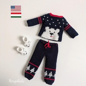 May include: A navy blue crochet doll outfit featuring a sweater with a white polar bear face and star accents, matching pants, and white booties. The outfit has red trim and accents. The outfit is handmade.