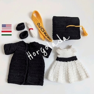 May include: Crocheted graduation outfit for a doll, including a black gown, cap, white dress, and yellow sash with the year 2023 embroidered on it.