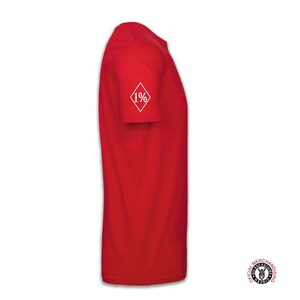 May include: Red short-sleeved t-shirt with a white diamond patch on the left sleeve that says "1%".