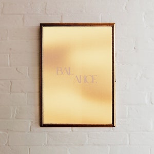 May include: A gold framed picture with a yellow background and the word "BALANCE" written in a light pink font.
