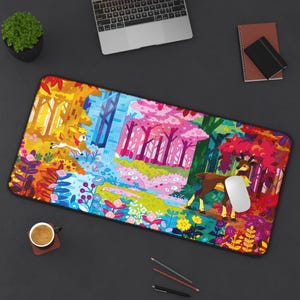 May include: A vibrant mouse mat depicting a cartoon forest scene with deer. The design uses bright colours including yellow, orange, blue, and pink, creating a lively landscape. A white computer mouse sits on the mat.