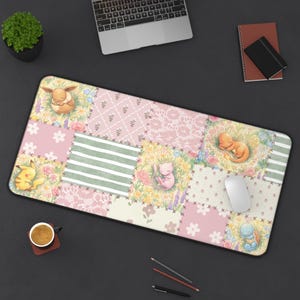 May include: A rectangular desk mat with a patchwork design in pastel pink, green, and floral patterns. The mat features illustrations of sleeping Pokémon characters, including Pikachu, Eevee, Charmander, Mew, and Squirtle. A mouse and laptop are also visible.