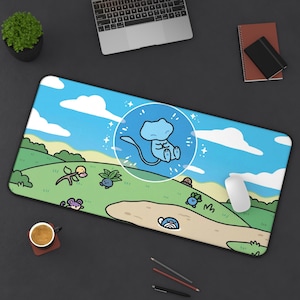 May include: A rectangular mousepad featuring a cartoon landscape with a blue sky, white clouds, and green hills. A blue cartoon character is in a white circle. Other cartoon characters are scattered across the landscape.