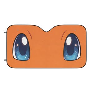 May include: A rectangular orange car sunshade featuring a graphic of two large, expressive blue eyes with white highlights. The sunshade has rounded corners, a black border, and a central cutout along the top edge, mimicking a cartoon character face.