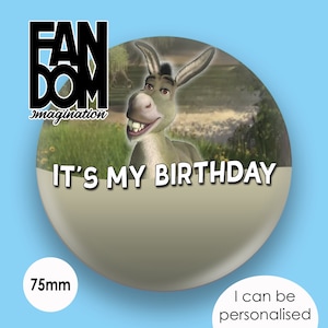 Könnte beinhalten: Ein runder Knopf mit einem Durchmesser von 75 mm, der einen Cartoon-Esel aus dem Film Shrek zeigt. Der Esel lächelt und der Text "It's My Birthday" ist auf dem Knopf aufgedruckt.
