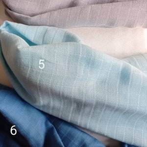 May include: Close-up of folded fabric samples in various shades of blue and gray. The fabrics have a textured, ribbed appearance. The samples are labeled with numbers 4, 5, and 6.