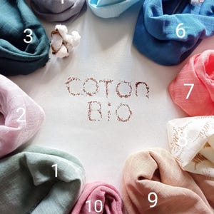 May include: An assortment of ten colorful, folded cotton scarves in shades of teal, pink, blue, and gray, arranged around the words "coton bio". The scarves are made of soft, lightweight fabric, perfect for a variety of uses.