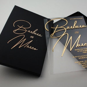 May include: A clear acrylic wedding invitation with gold foil lettering. The invitation reads "With great pleasure Barbara and Marco invites you to join at the celebration of their wedding at ten o'clock in the morning, Saturday, January 12, 2019, PortMiami-Cruise Terminal 1015 North Miami, Miami, FL 33132, Carnival Cruise Lines."