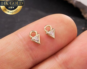 Puede incluir: Dos abalorios triangulares de oro con una piedra preciosa transparente en el centro. Cada abalorio tiene un bucle en la parte superior para sujetarlo a joyas.