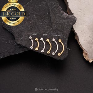 May include: A set of five 14k gold curved barbell body jewelry pieces in different sizes. The barbells are 6mm, 8mm, and 10mm in length and are 16 gauge. The barbells are on a black background.