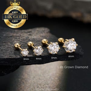 May include: A collection of gold-colored stud earrings with clear, sparkling, lab-grown diamonds. The earrings are displayed in sizes 3mm, 4mm, 5mm, and 6mm. The image includes a gold seal that reads "14K GOLD".