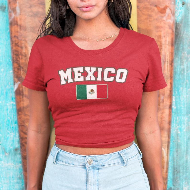 May include: Red cropped t-shirt with the word "MEXICO" in white letters and the Mexican flag printed on the front.