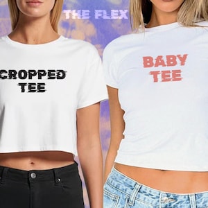 May include: Two white cropped t-shirts with different text. The first shirt says "CROPPED TEE" in black text. The second shirt says "BABY TEE" in pink text.