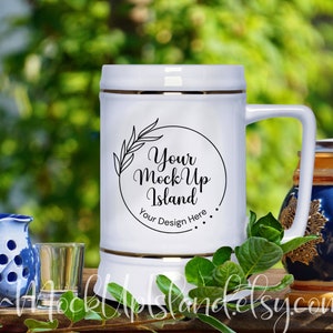 Può includere: Un boccale di birra in ceramica bianca con un bordo dorato e un design nero che dice "Your Mock Up Island" e "Your Design Here".