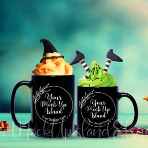 Puede incluir: Dos tazas negras con texto blanco que dice "Your Mock Up Island" y un espacio para texto que dice "Your Design Here". Las tazas están llenas de glaseado naranja y verde con decoraciones de sombrero de bruja y piernas de bruja.