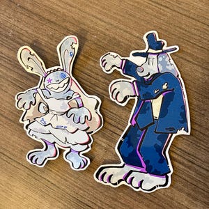 Puede incluir: Dos personajes de dibujos animados vestidos con atuendos de boda. El personaje de la izquierda es un conejo que lleva un vestido blanco y un velo. El personaje de la derecha es un perro que lleva un traje azul y un sombrero. Ambos personajes tienen un aspecto desgastado y deteriorado.