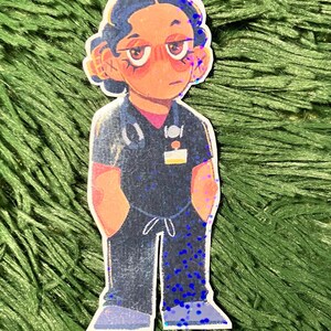 K&ouml;nnte beinhalten: Ein Aufkleber mit einer Cartoon-Illustration eines Angeh&ouml;rigen der Gesundheitsberufe in dunkelblauer Arbeitskleidung mit einem Stethoskop. Der Aufkleber hat einen holografischen Effekt mit blauen Glitzerakzenten. Die Figur hat einen ernsten Gesichtsausdruck.