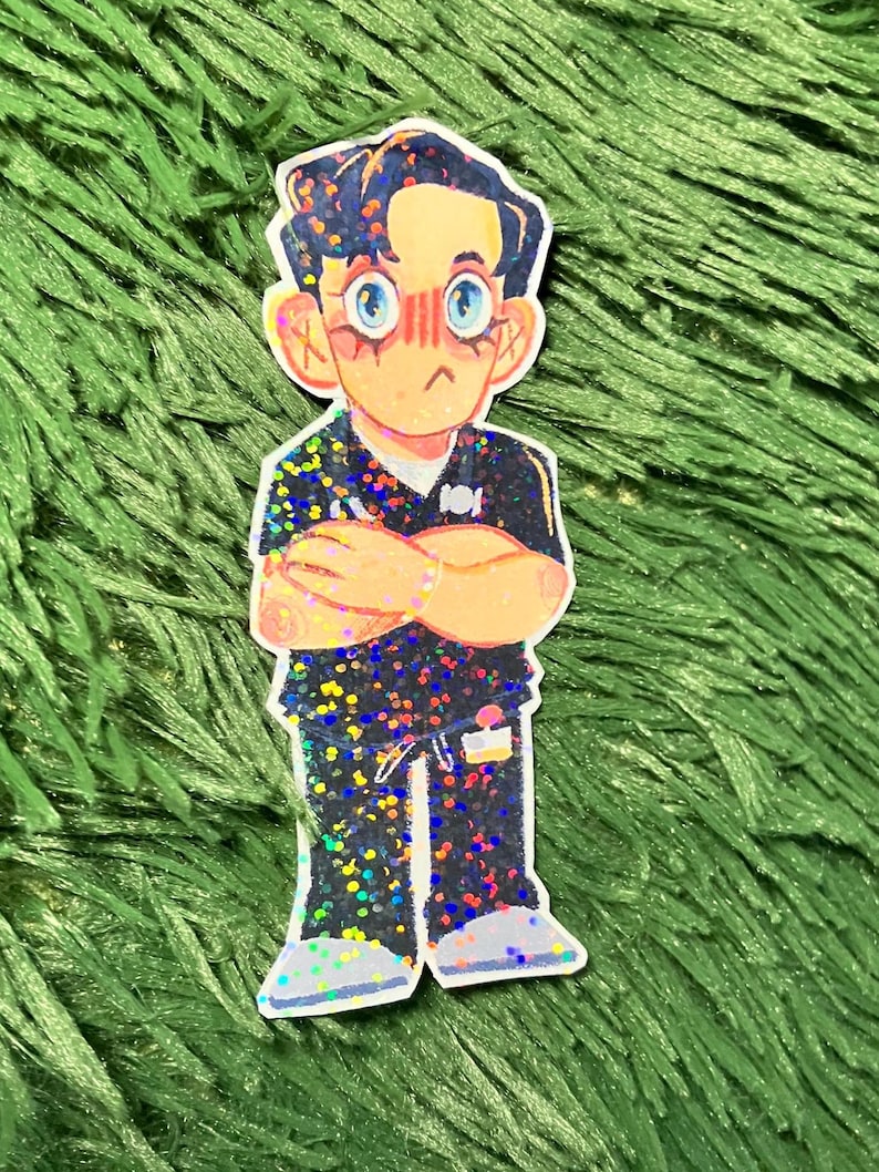 K&ouml;nnte beinhalten: Ein Aufkleber mit einer Cartoon-Illustration einer Person mit verschr&auml;nkten Armen. Die Figur hat dunkles Haar, blaue Augen und ein ger&ouml;tetes Gesicht. Die Kleidung ist schwarz mit bunten Glitzerakzenten. Der Aufkleber befindet sich auf einem gr&uuml;nen, strukturierten Hintergrund.