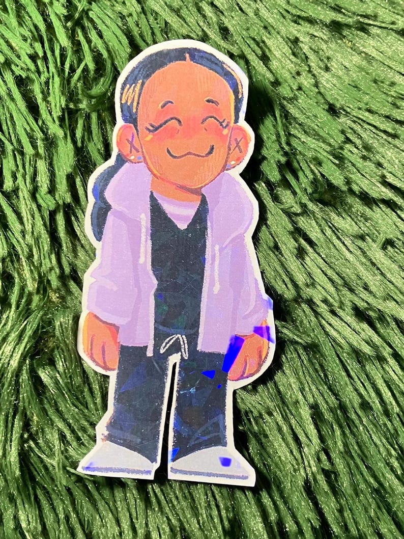 K&ouml;nnte beinhalten: Ein Aufkleber mit einer Cartoon-Illustration einer Person, die eine lila Kapuzenjacke, ein schwarzes Hemd und eine schwarze Hose tr&auml;gt. Die Person hat dunkles Haar und l&auml;chelt. Der Aufkleber hat einen holografischen Effekt.