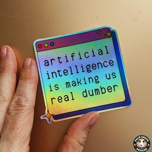 May include: A holographic sticker with the text "artificial intelligence is making us real dumber." The sticker is in the shape of a computer window with a colorful gradient background and star accents.