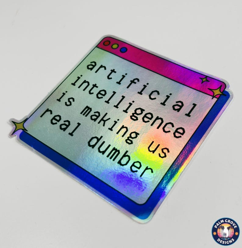 May include: Holographic sticker with the text "artificial intelligence is making us real dumber." The sticker has a window-like design with a pink and blue border and star accents. The Palm Grove Designs logo is in the bottom right corner.