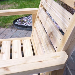 K&ouml;nnte beinhalten: Ein Holzstuhl mit einer Lattenr&uuml;cklehne und einem Latten-Sitz. Der Stuhl ist aus unbehandeltem Holz und hat eine nat&uuml;rliche Farbe.