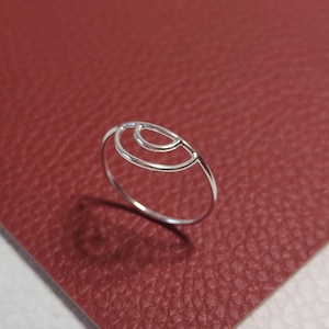 Könnte beinhalten: Ein silberner Ring mit einem geometrischen Design aus überlappenden Kreisen.