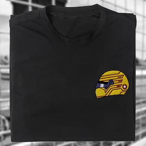 Peut inclure: T-shirt noir avec un casque jaune brodé avec des détails rouges et bleus.