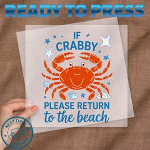 May include: A heat transfer sheet with a crab design. The orange crab is surrounded by starfish, shells, and the text "IF CRABBY PLEASE RETURN to the beach" in blue. The words "READY TO PRESS" are at the top.