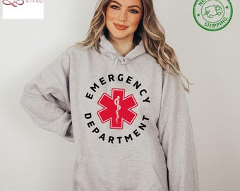 May include: Gray hooded sweatshirt with a black and red graphic of a medical symbol and the text "Emergency Department".