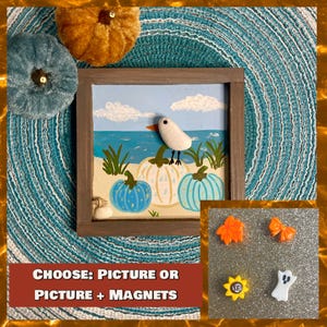 May include: A framed painting with a beach scene featuring a white bird, pumpkins, and blue water. The painting is surrounded by decorative pumpkins and a teal placemat. The text at the bottom reads "CHOOSE: PICTURE OR PICTURE + MAGNETS."