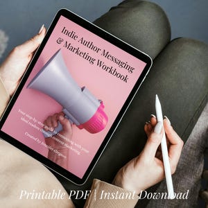 Könnte beinhalten: Ein digitales Tablet, das ein Arbeitsbuch mit dem Titel "Indie Author Messaging & Marketing Workbook" anzeigt. Das Cover zeigt eine Megaphon-Grafik in Grau und Rosa auf rosa Hintergrund. Der Text "Printable PDF | Instant Download" befindet sich unten.