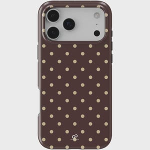 Puede incluir: Funda de teléfono marrón con un patrón repetido de pequeños lunares de color beige claro. La funda tiene un acabado brillante y un recorte para un sistema de cámara de múltiples lentes. La marca "ART OD" está impresa en la parte inferior.