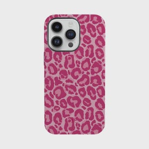 Puede incluir: Una funda de teléfono rosa con un diseño de estampado de leopardo. La funda tiene un acabado brillante y un recorte para la cámara. Las manchas de leopardo son en diferentes tonos de rosa, creando un aspecto texturizado. La funda está diseñada para un smartphone.