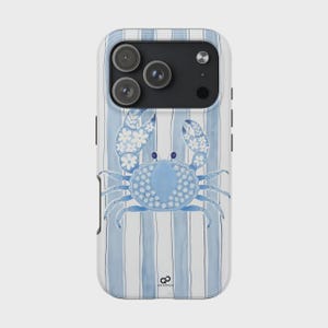 May include: A phone case featuring a blue crab design on a striped background. The crab is light blue with white floral accents. The case has a white and blue striped pattern and a camera cutout.