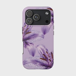 May include: A lavender phone case featuring a floral design of purple lilies with brown stamens. The case has a glossy finish and a raised edge for camera protection. The phone case is designed to fit a smartphone.