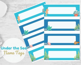 May include: Under the Sea Name Tags printable sheet with blue and light blue rectangular labels featuring sea creatures like a seahorse, starfish, and a clownfish. Each label has a blank space for writing names.