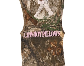 May include: A brown and green camouflage tank top with the words "COWBOY PILLOWS" printed in pink on the front.
