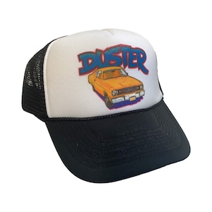 May include: A white and black trucker hat with a yellow car and the word "Duster" in blue and red lettering.